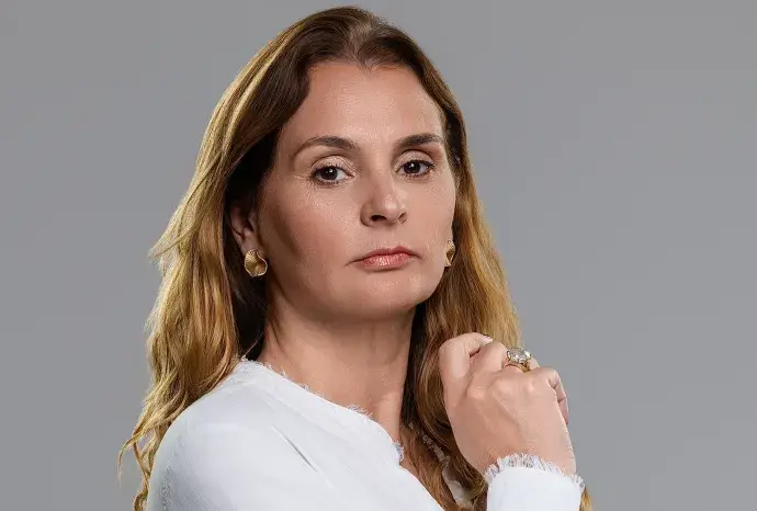 Pessoa profissional olhando para frente em postura decisiva, com fundo desfocado de uma sala